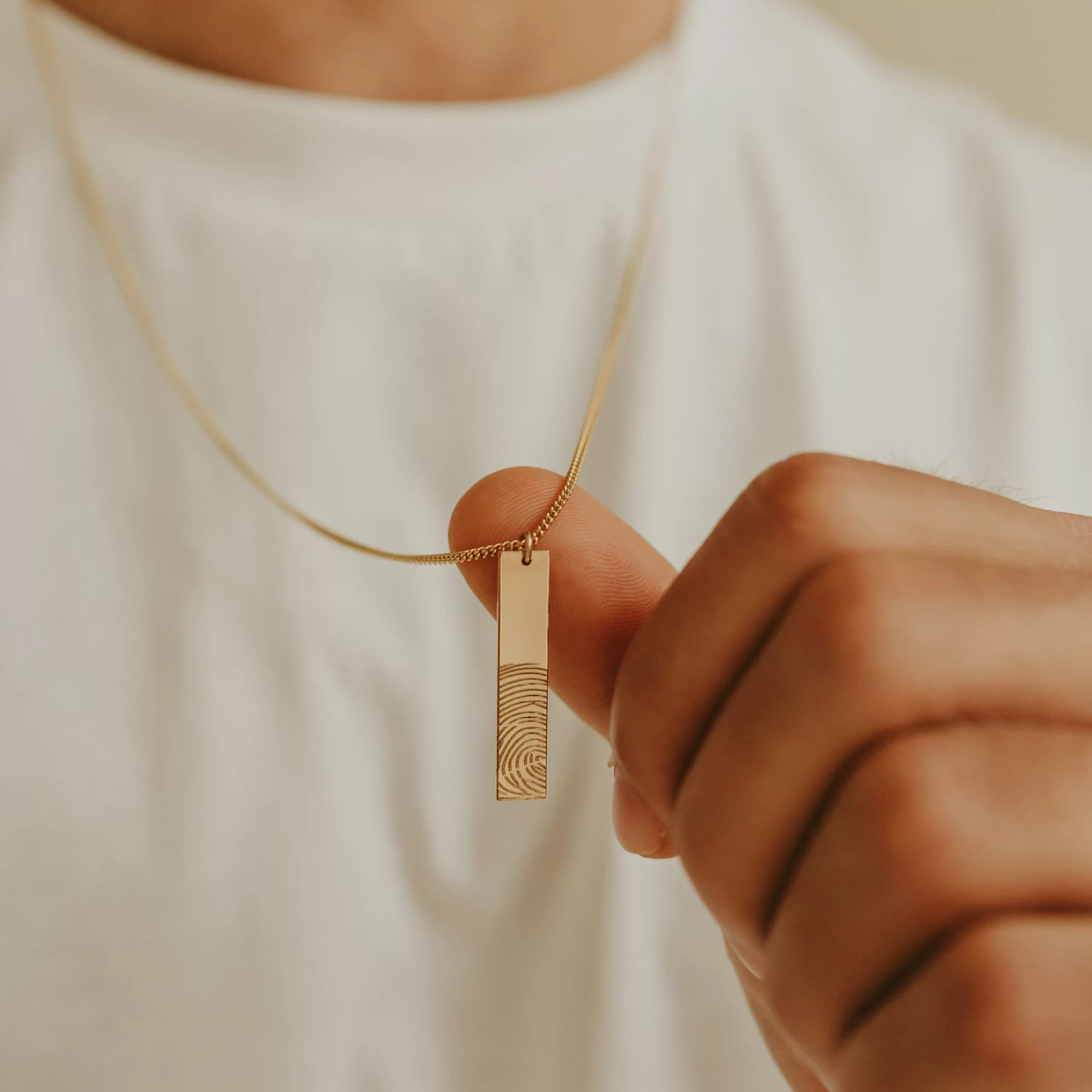 Duim beklemtoont de personalisatie van een mannen ketting bar